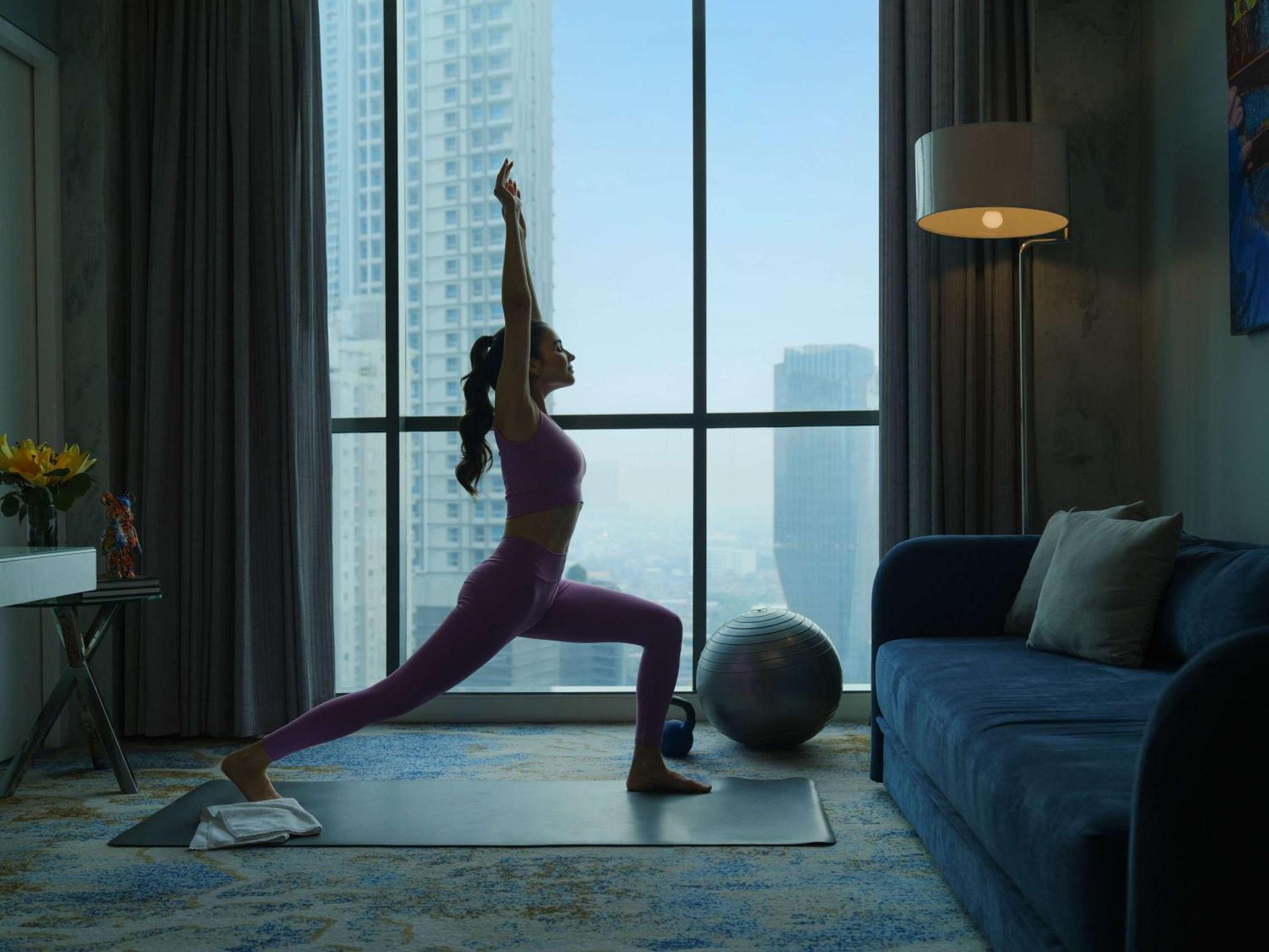 Pullman Jakarta Central Park Exterior foto A woman practicing yoga at home